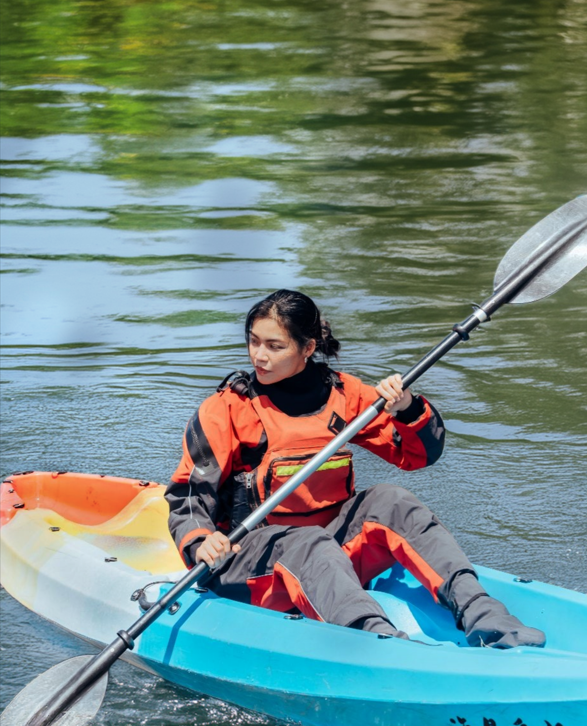 Person wearing a PORLITE® dry suit made with breathable and waterproof fabric while kayaking