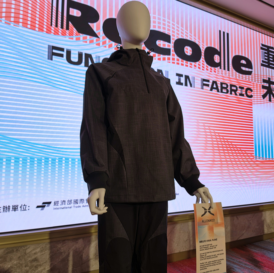 ALLENKO3 dark grey hooded half-zip jacket and paneled pants made with Hwafune PORLITE® fabrics, displayed at the RECODE 2050 fashion show at TITAS
